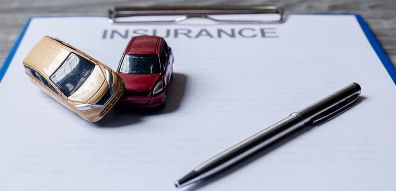 Car and pen on insurance documents. Car insurance concept