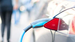 An electric car is charged with energy by a road dispenser