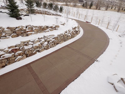 A colored concrete walkway stands up to harsh winter conditions thanks to proper cold weather concreting practices—proof that durability and aesthetics can go hand in hand, even in freezing temperatures.