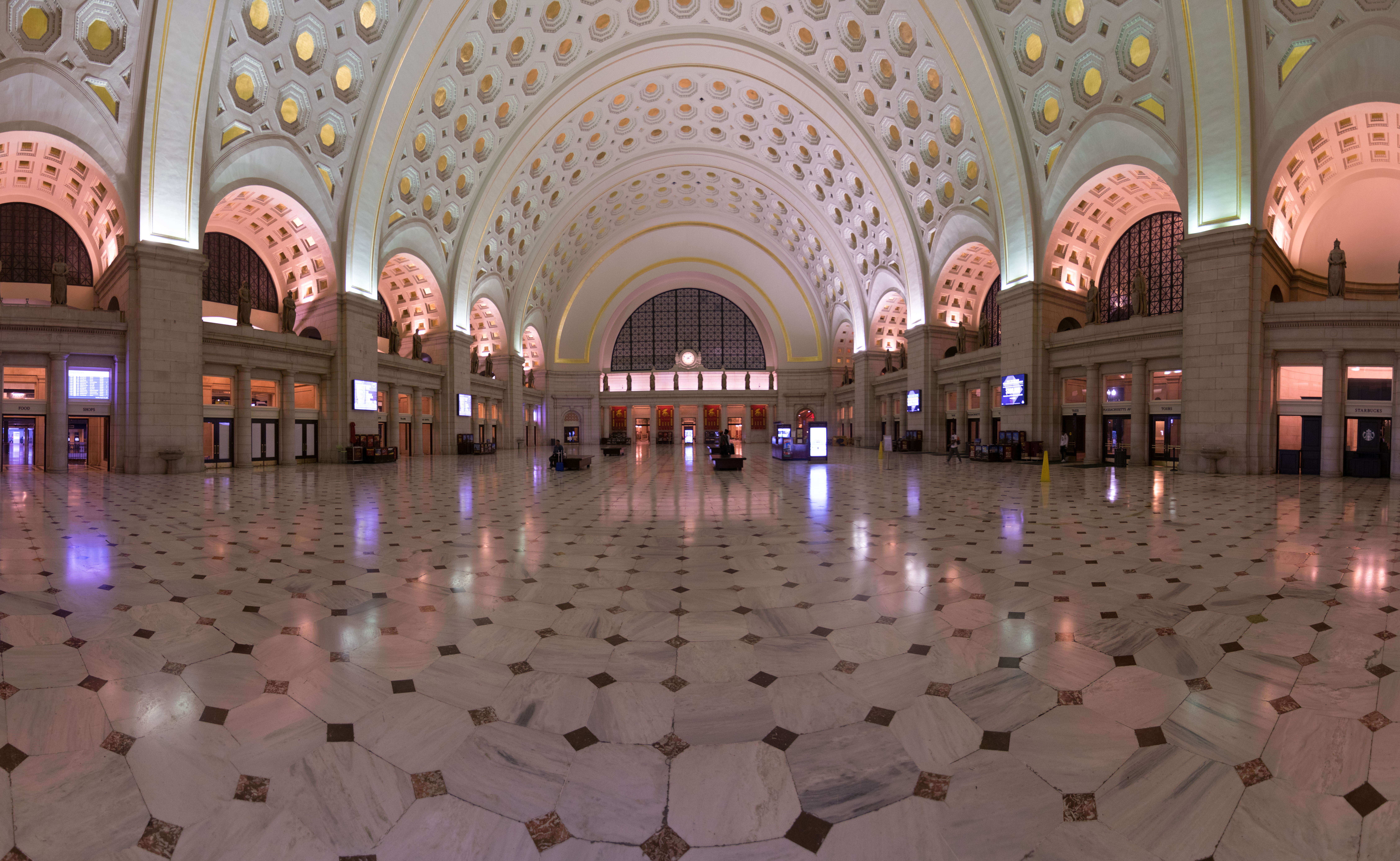 Grand interior hall of Union Station featuring ornate coffered ceiling with geometric patterns, illuminated arches, and symmetrical architectural design
