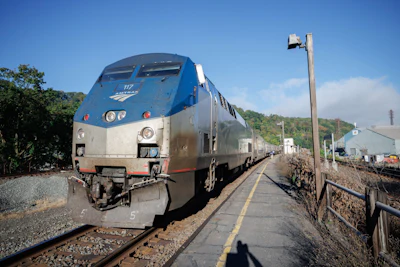 Amtrak passenger train locomotive number 117 at a railway station platform with blue and silver exterior