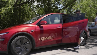 A rider boards a driverless Tesla robotaxi, a ride-booking service, Sunday, June 22, 2025, in Austin, Texas.