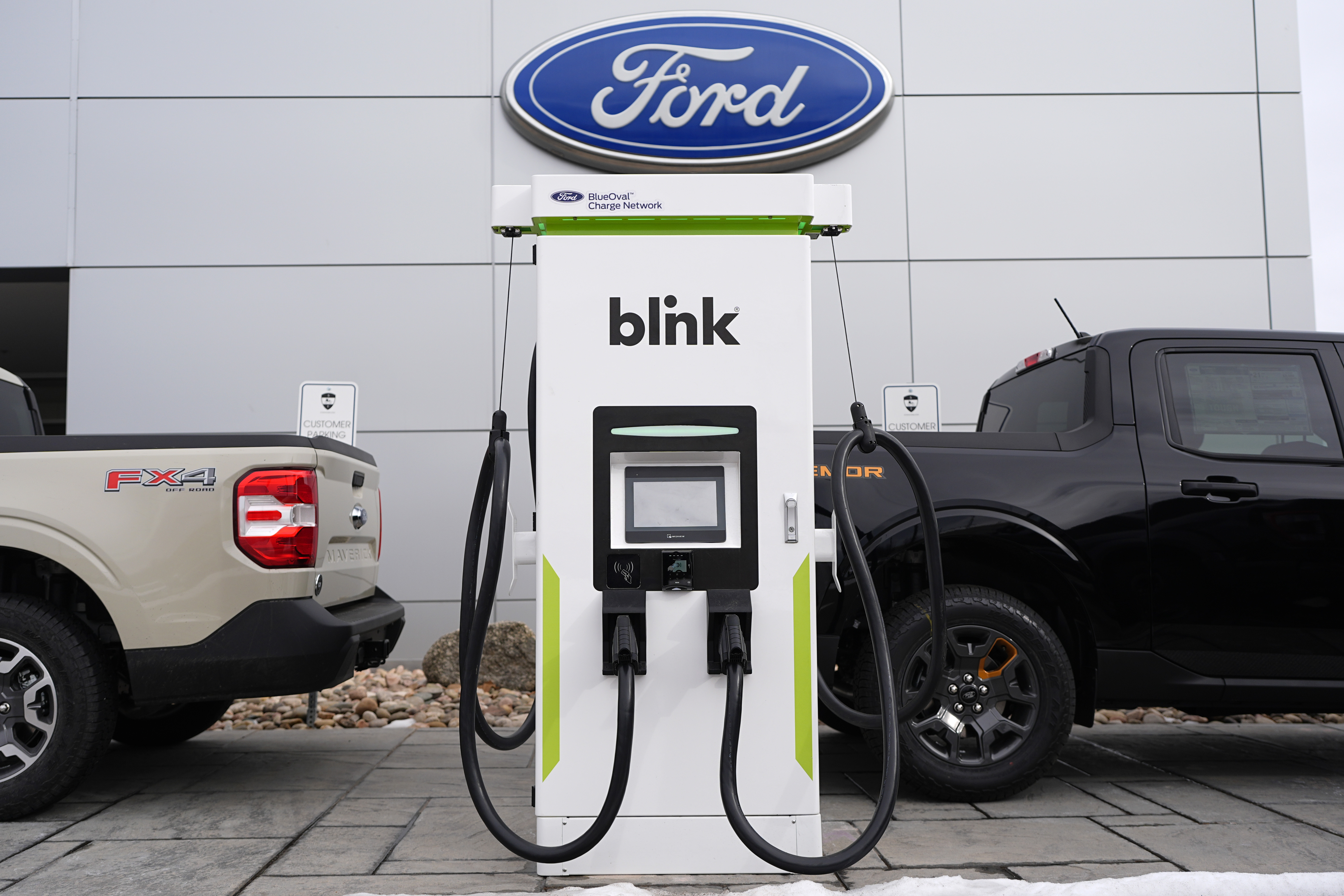 Electric vehicle chargers sit outside a Ford dealership, Jan. 21, 2024, in Broomfield, Colo.