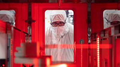 An employee monitors a wafer transfer at one of Texas Instruments’ 300mm semiconductor fabs in Sherman, Texas, SM1.