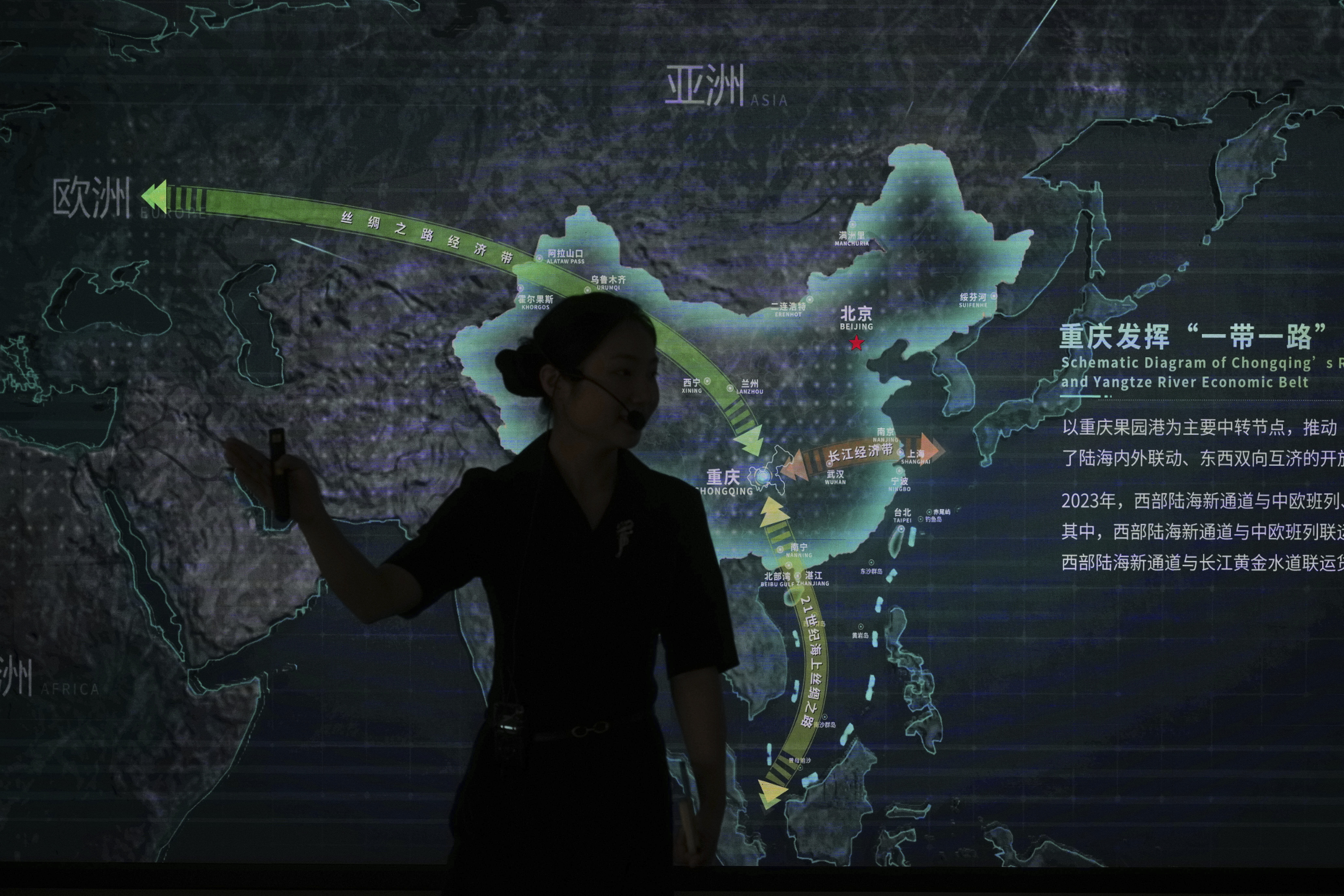 A worker walks by a display board showing the Chongqing Railway Hub for the One Belt One Road project, at the Chongqing Railway Container Terminal Station in southwest China's Chongqing Municipality on Tuesday, May 20, 2025.