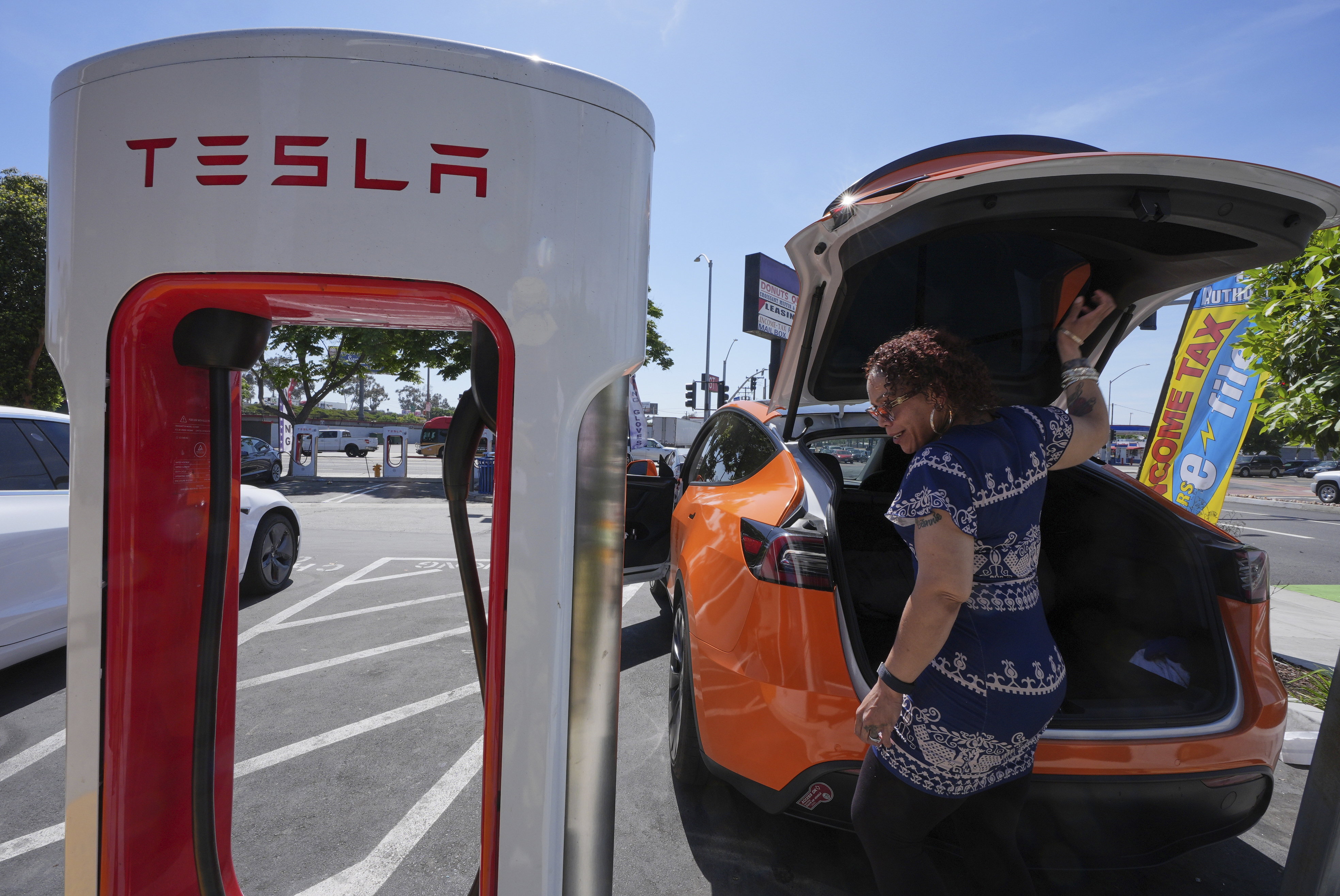 Janelle Lowe prepares to charge her electric vehicle at a station May 22, 2025, in Long Beach, Calif.