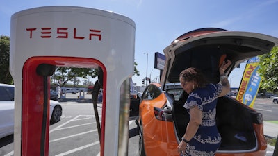 Janelle Lowe prepares to charge her electric vehicle at a station May 22, 2025, in Long Beach, Calif.