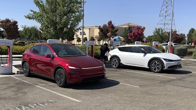 This photo provided by Edmunds shows a Tesla Model Y and a Kia EV6 parked at a Tesla Supercharger station in Fresno, Calif. Planning a cross-country trip in an EV takes extra effort, but doing it properly can make the journey almost as smooth as in a gas-powered vehicle.