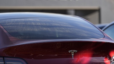 A Tesla model Y and other Telsla vehicles sit at a dealership, Wednesday, March 19, 2025, in Kennesaw, Ga.