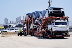 A transport carrying new cars arrives at a Stellantis facility July 10, 2023, in Belvidere. Ill.
