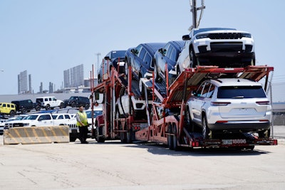 A transport carrying new cars arrives at a Stellantis facility July 10, 2023, in Belvidere. Ill.