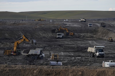 Excavators load material onto autonomous mining trucks in the Huaneng Yimin open-pit coal mine in Hulunbuir in northern China's Inner Mongolia province China, Monday, Sept. 15, 2025.