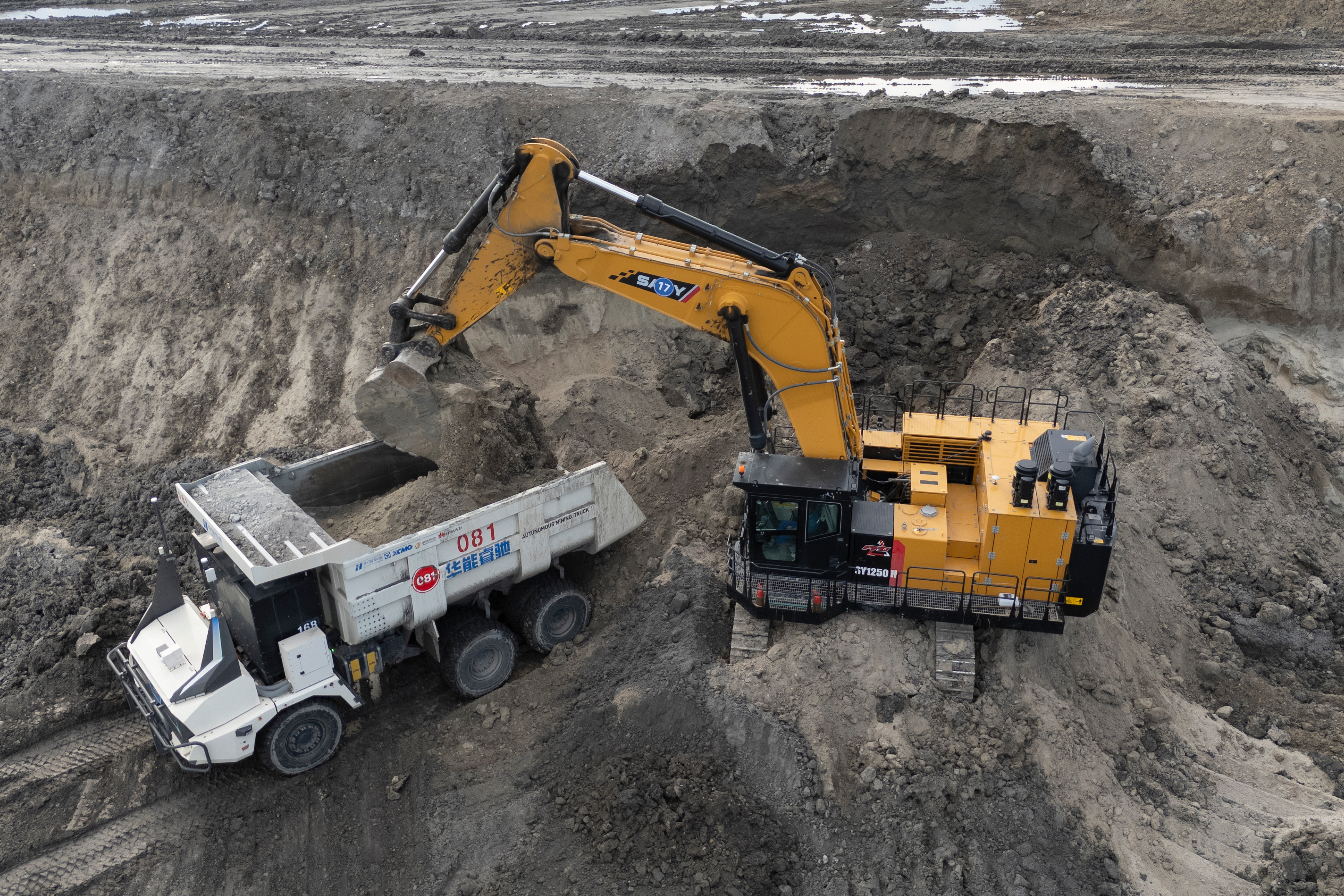 An excavator loads an autonomous mining truck in the Huaneng Yimin open-pit coal mine in Hulunbuir in northern China's Inner Mongolia province China, Monday, Sept. 15, 2025.
