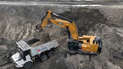 An excavator loads an autonomous mining truck in the Huaneng Yimin open-pit coal mine in Hulunbuir in northern China's Inner Mongolia province China, Monday, Sept. 15, 2025.
