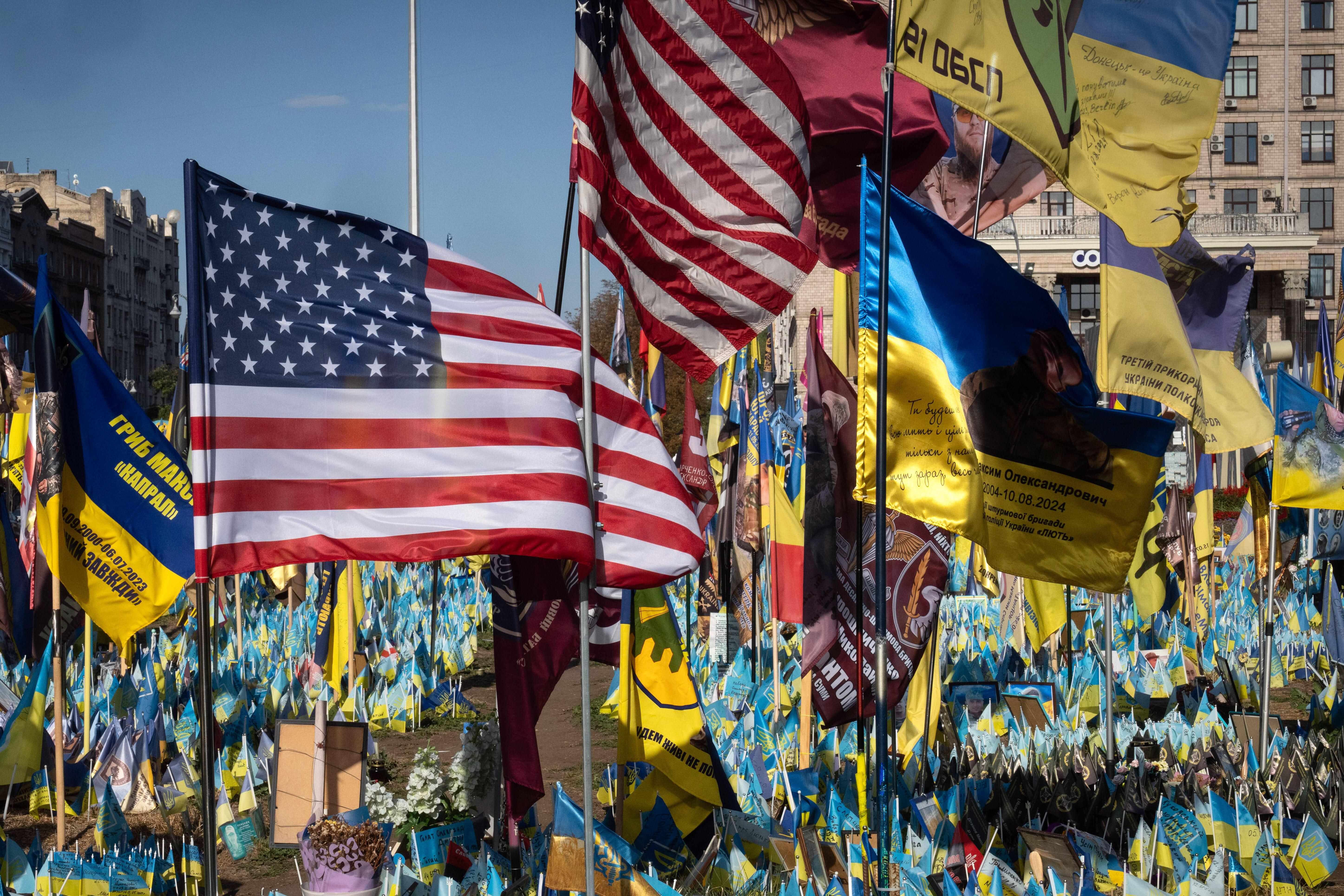US and Ukrainian national flags wave to commemorate American volunteers, who were killed in battles with Russian troops defending Ukraine, their names are on flags, at the improvised war memorial in Independence square in Kyiv, Ukraine, Sept. 27, 2024.