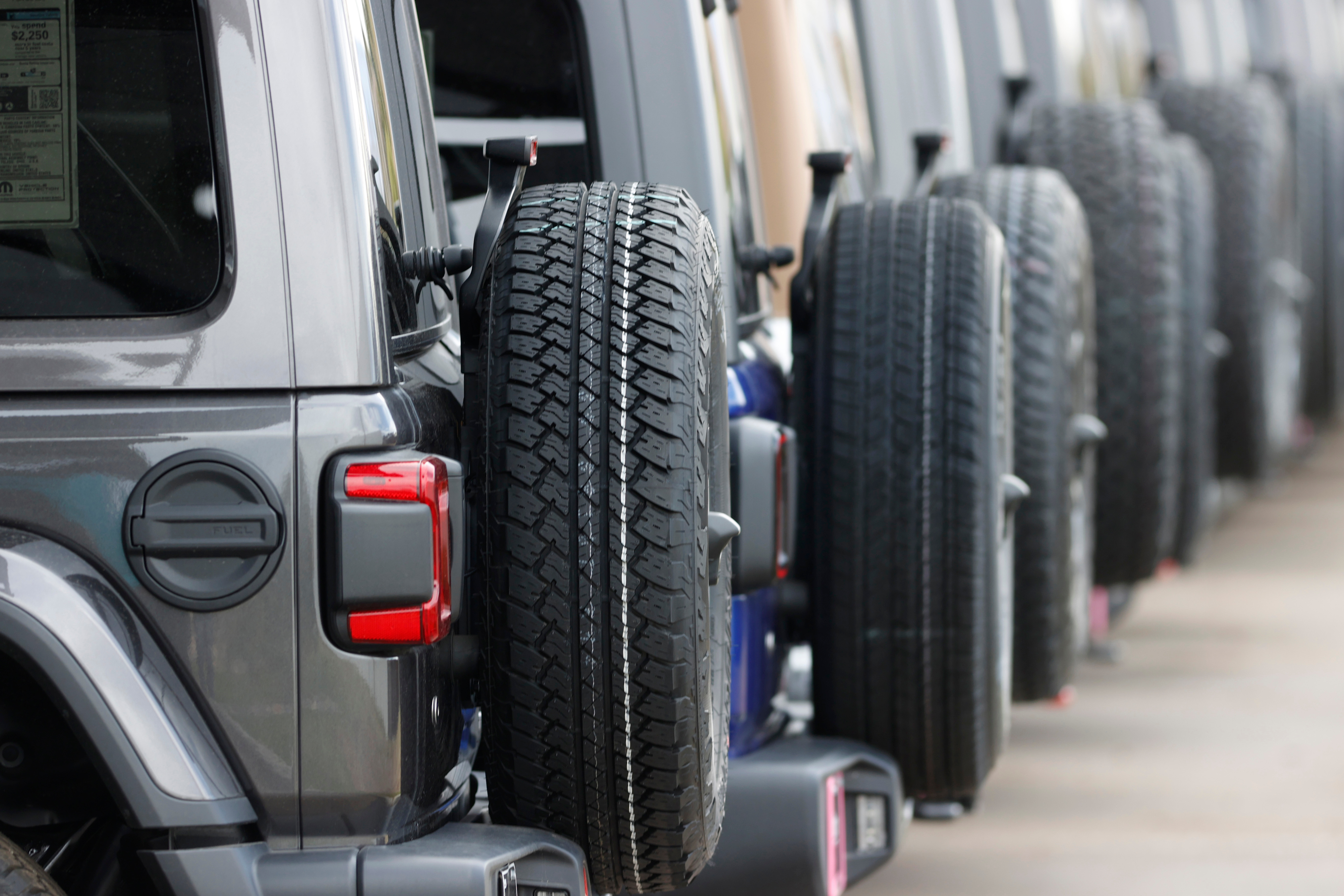 Spare tires are seen on a long row of unsold 2020 Wranglers sit at a Jeep dealership in Englewood, Colo., on April 26, 2020.