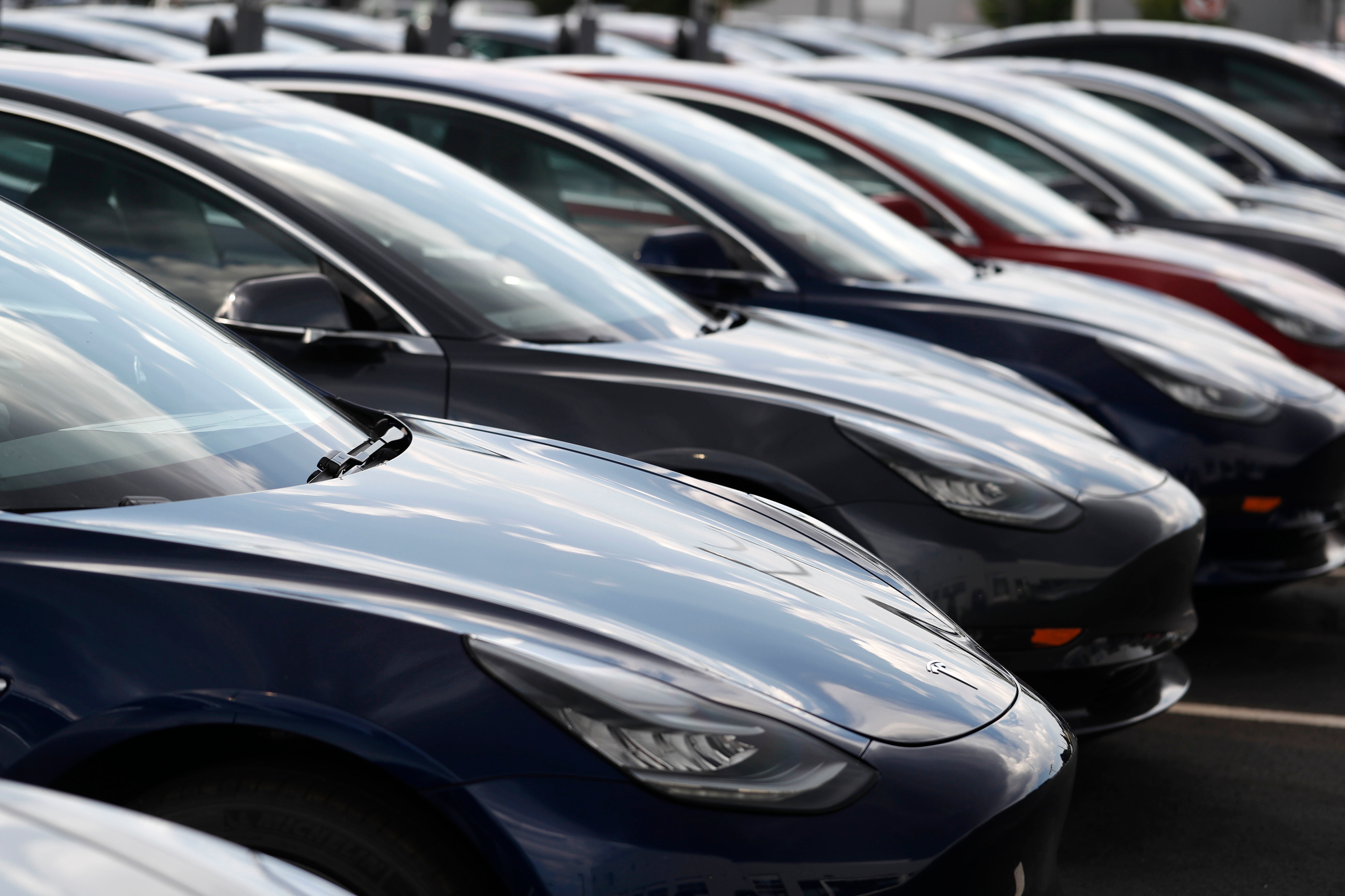 Several 2018 Model 3 sedans sit on display outside a Tesla showroom, July 8, 2018, in Littleton, Colo.