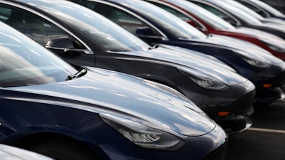 Several 2018 Model 3 sedans sit on display outside a Tesla showroom, July 8, 2018, in Littleton, Colo.