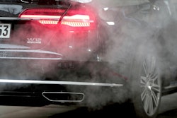 A luxury Audi car is surrounded by exhaust gases as it is parked with a running engine in front of the Chancellery in Berlin, Germany, Wednesday, Nov. 20, 2019.