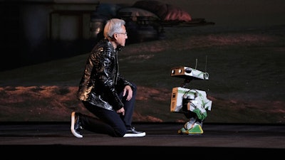 Nvidia founder and CEO Jensen Huang kneels in front of a robot during a Nvidia news conference ahead of the CES tech show Monday, Jan. 5, 2026, in Las Vegas.