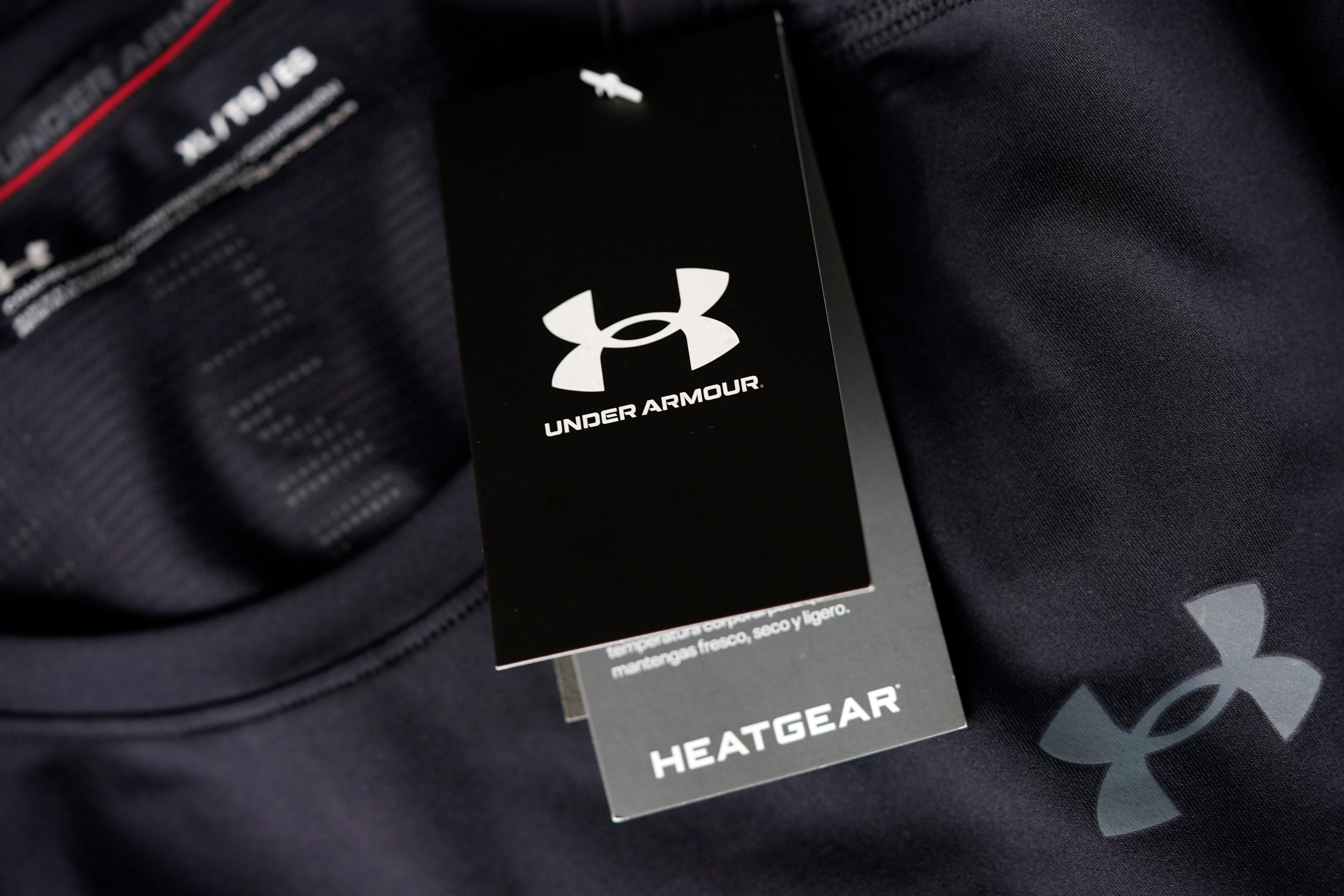 The company logo graces a sales tag on a compression shirt for sale in an Under Armour store in an outlet mall on May 3, 2021, in Lakewood, Colo.