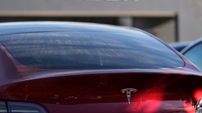 A Tesla model Y and other Telsla vehicles sit at a dealership, Wednesday, March 19, 2025, in Kennesaw, Ga.