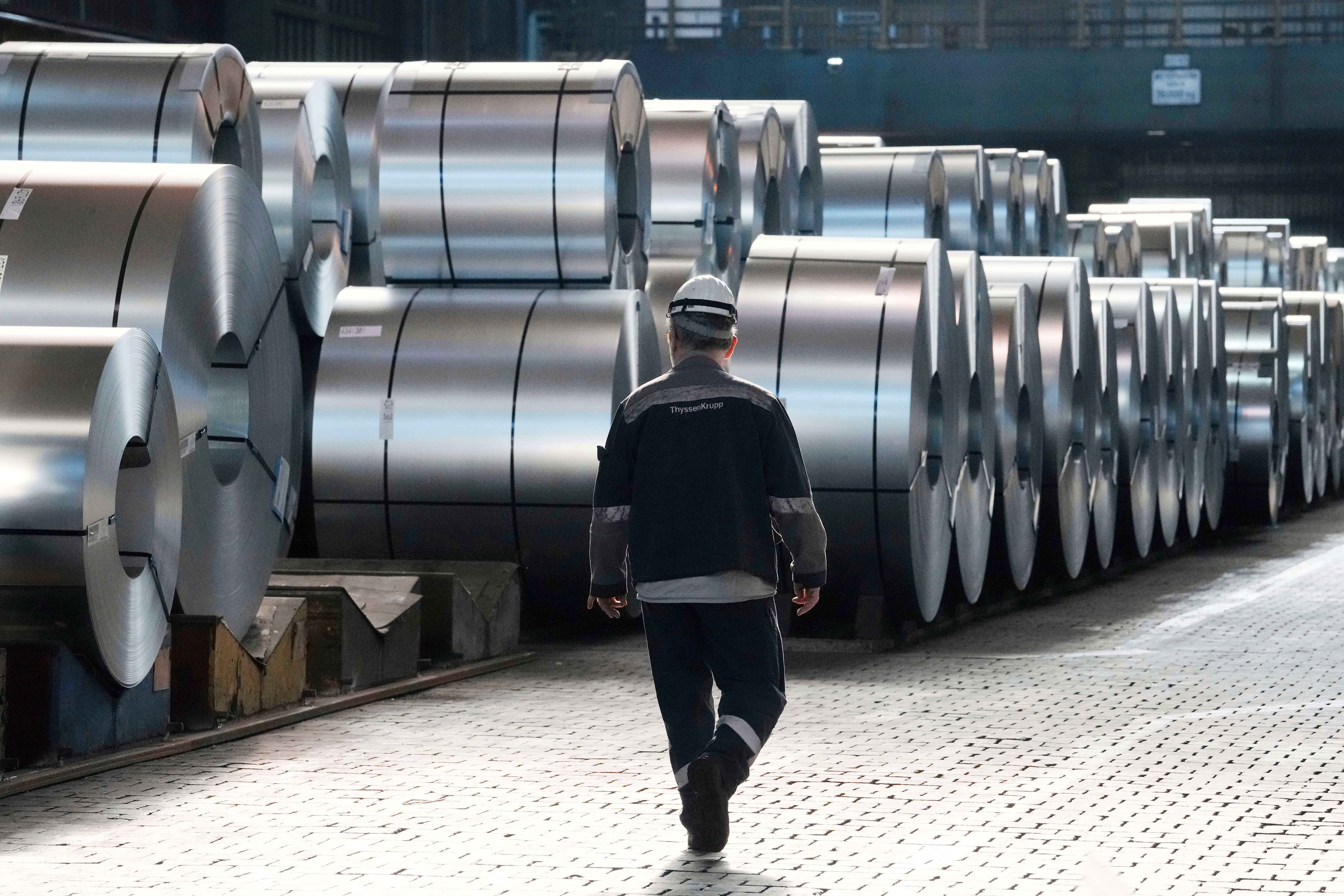 A steel worker walks beside steel coils at the Thyssenkrupp steelworks in Duisburg, Germany, March 20, 2025.