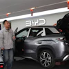 Visitors walk by a hybrid car at a BYD showroom in Beijing, China, Thursday, March 26, 2026.