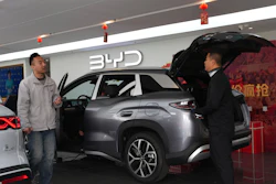 Visitors walk by a hybrid car at a BYD showroom in Beijing, China, Thursday, March 26, 2026.