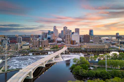 The Minneapolis, Minnesota, city skyline over the river at dusk.