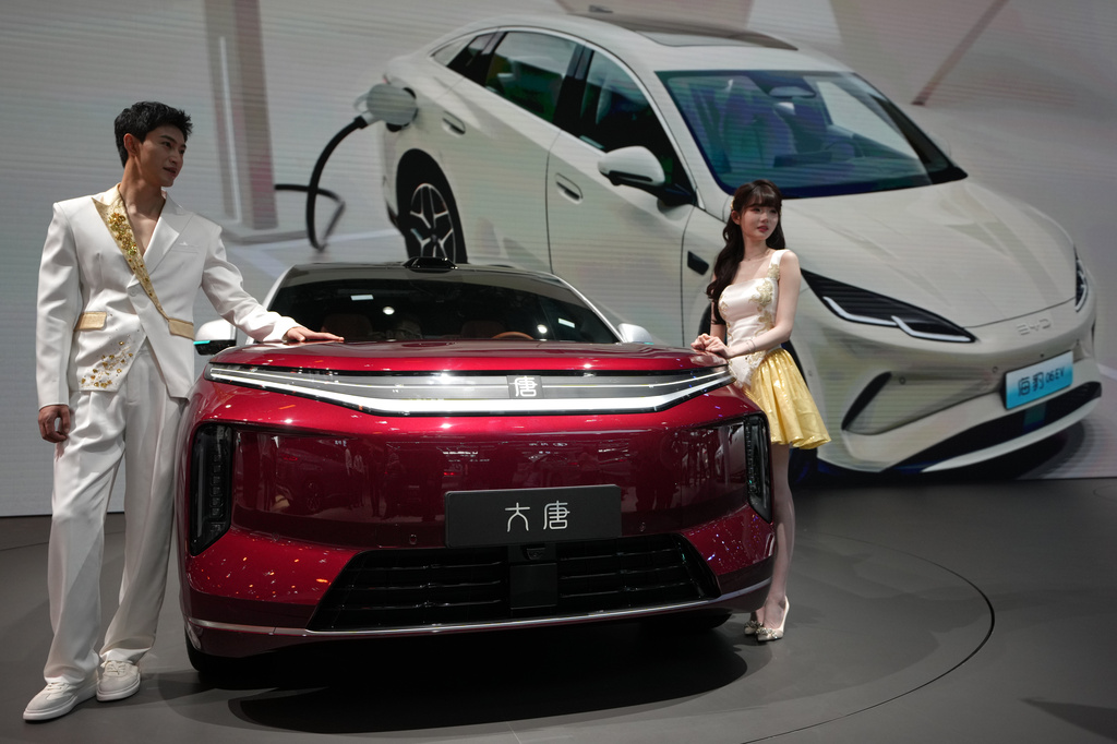 Models stand next to a latest EV car from Chinese automaker BYD showcased at the Auto China 2026, in Beijing, April 25, 2026.