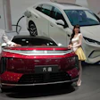 Models stand next to a latest EV car from Chinese automaker BYD showcased at the Auto China 2026, in Beijing, April 25, 2026.