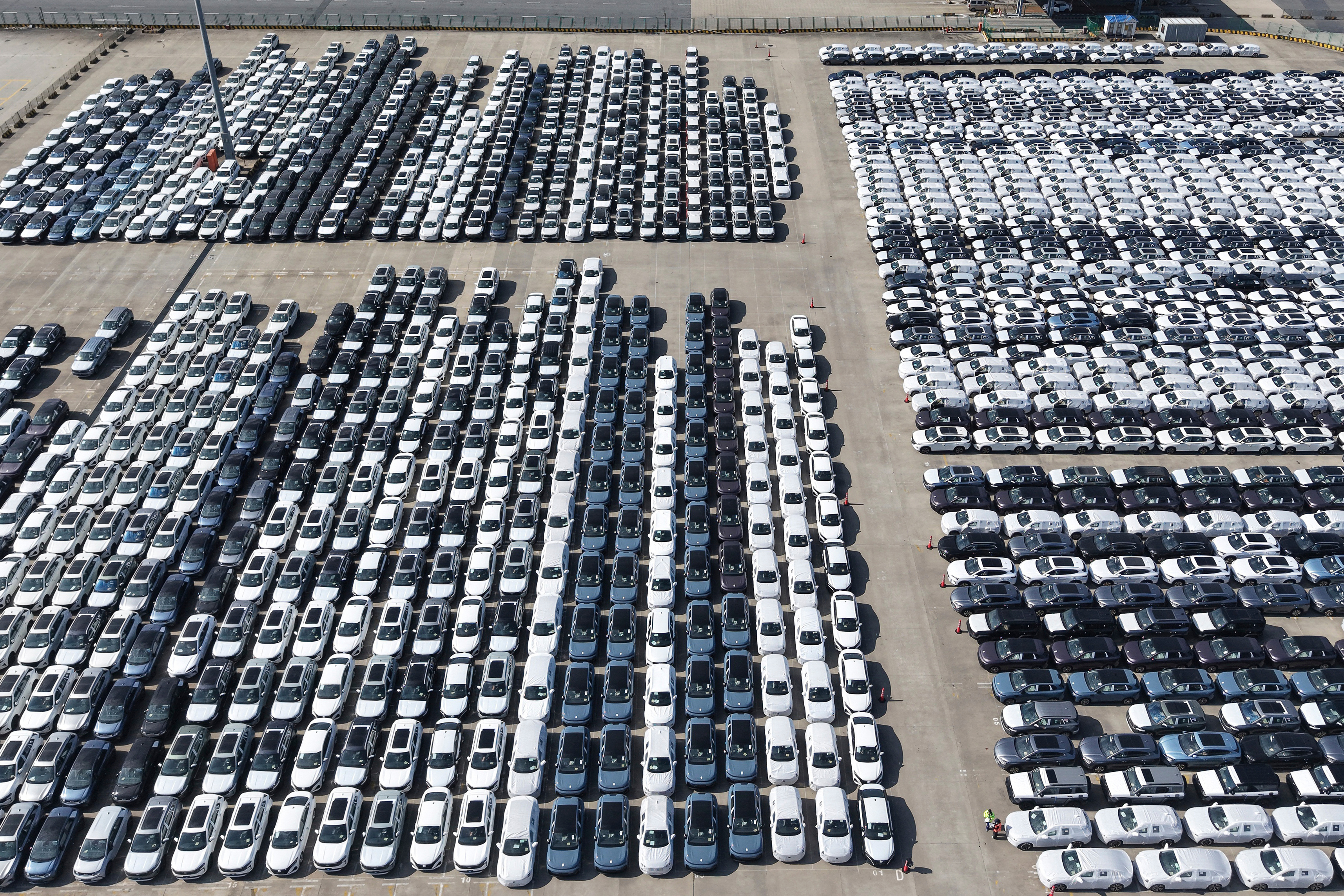 An aerial view of new cars awaiting export to oversea markets is seen at a port in Shanghai, March 10, 2026.