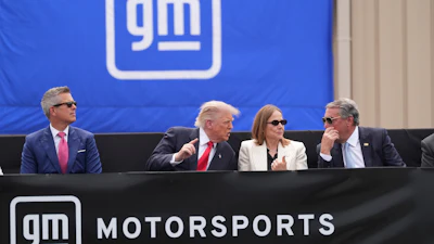 President Donald Trump, center left, speaks with Mary Barra, chair and CEO of General Motors, center right, and General Motors President Mark Reuss, right, as Transportation Secretary Sean Duffy listens at left, during a driving demonstration at General Motors proving ground, Monday, July 27, 2026, in Milford, Mich.