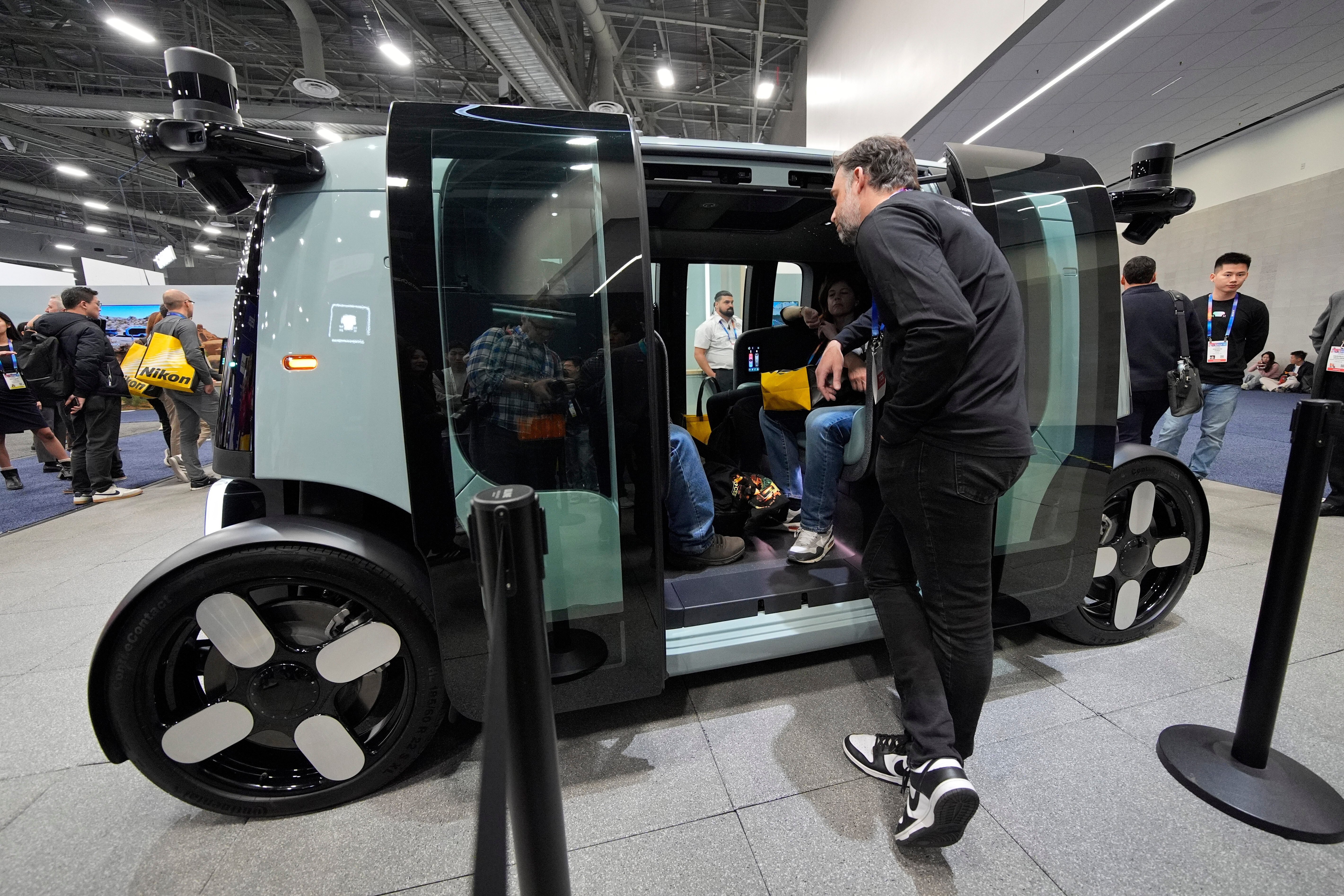 People view a Zoox self-driving vehicle at the company's booth during the CES tech show, Jan. 7, 2025, in Las Vegas.
