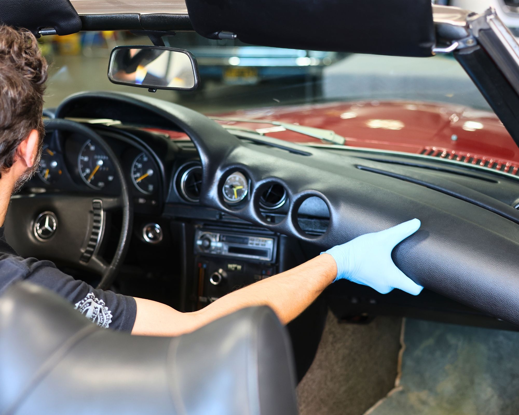 A Just Dashes technician demonstrates the padded construction and fitted appearance of SoftCap during installation in a classic Mercedes-Benz SL.