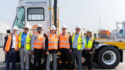 Orange EV and APM Terminals team members gather alongside an Orange EV electric terminal truck.