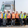 Orange EV and APM Terminals team members gather alongside an Orange EV electric terminal truck.